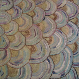 Textured rug featuring overlapping semi-circle patterns in muted blue, purple, olive, and tan colors.
