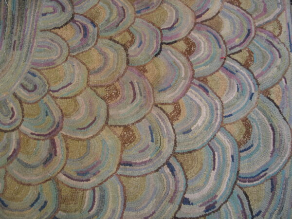 Textured rug featuring overlapping semi-circle patterns in muted blue, purple, olive, and tan colors.