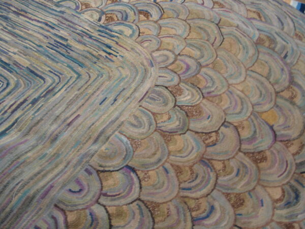Close detail of a high-texture rug blending short segmented blue stripes with beige scale patterns.