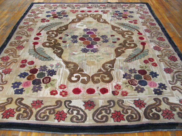 Textured rug featuring a dense, colorful floral and scroll pattern in beige, purple, and maroon on wood plank flooring.