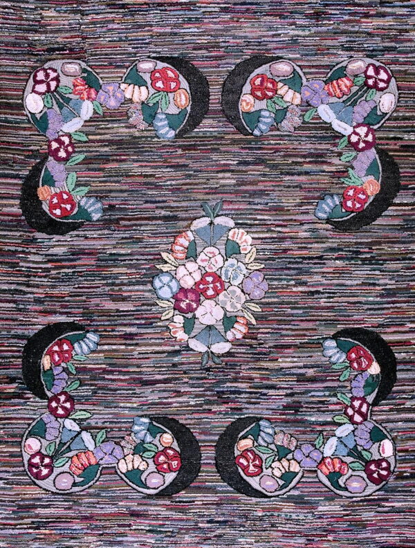 Striped multicolor rug with symmetrical floral motifs featuring blooms of red, purple, pink, and green.