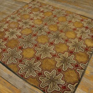 Textured gold rug with repeating taupe and red medallion patterns rests on distressed plank flooring.