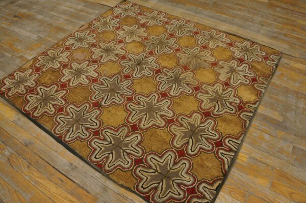 Textured gold rug with repeating taupe and red medallion patterns rests on distressed plank flooring.