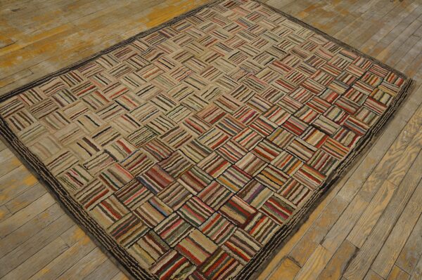 Textured rug with multicolored stripes forming a basketweave pattern rests on distressed wood flooring.