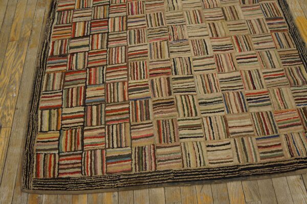 Textured multicolor striped block rug with a dark border resting on light brown wood flooring.