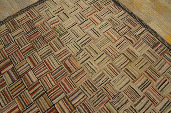 A textured, multicolored rag rug with a striped herringbone pattern rests on distressed light wood planks.