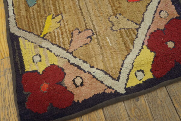 A high-texture rug with abstract floral patterns in red, yellow, beige, and purple on wide wood planks.