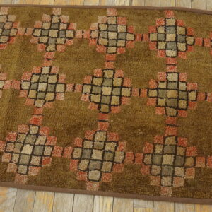 Textured brown runner with repeating tan and rust geometric diamonds rests on distressed light wood planks.