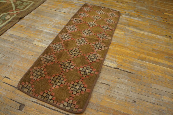 Olive-brown runner with high pile features geometric coral and tan diamond patterns on yellow distressed wood.
