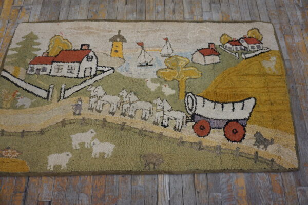Highly textured, multicolored rug depicting a scenic village, a covered wagon, sheep, and green hills.
