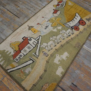 Beige, green, and yellow hooked rug with a colorful countryside motif on distressed wood flooring.