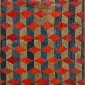 Shaggy pile rug featuring a repeating three-dimensional cube pattern in red, navy, and gold colors.