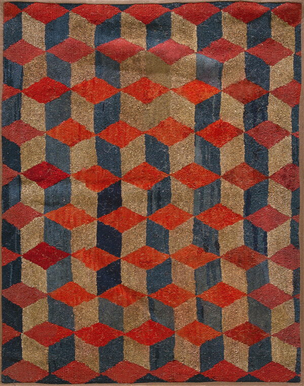 Shaggy pile rug featuring a repeating three-dimensional cube pattern in red, navy, and gold colors.