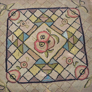 Textured rug with a central pink floral pattern inside a multicolored geometric diamond grid.