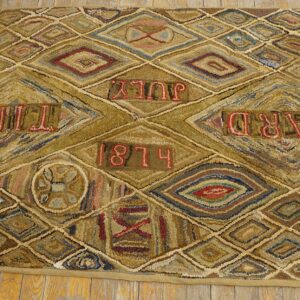 Textured rug with gold and brown diamond patterns displaying red text, including "HARD TIMES" and "1874."