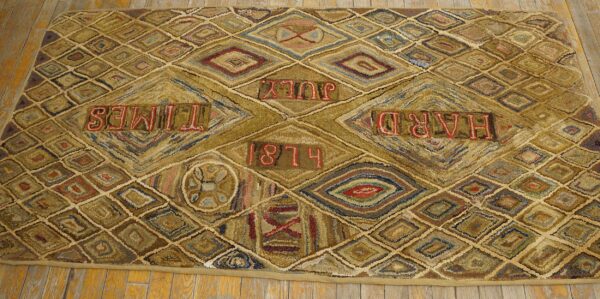 Textured rug with gold and brown diamond patterns displaying red text, including "hard times" and "1874. "