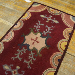 Textured maroon runner featuring an elaborate pastel floral design on rustic yellow hardwood floors.