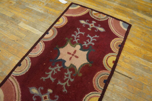 Textured maroon runner featuring an elaborate pastel floral design on rustic yellow hardwood floors.