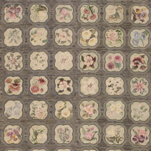 High-low pile gray rug featuring repetitive scalloped beige medallions with varied colorful floral motifs.