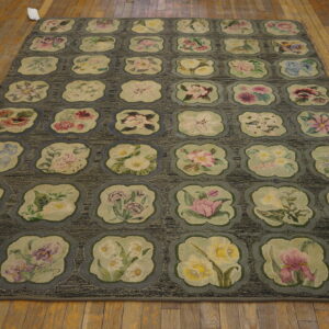 Textured gray rug with a grid of lobed medallions containing multicolored floral designs on wood flooring.