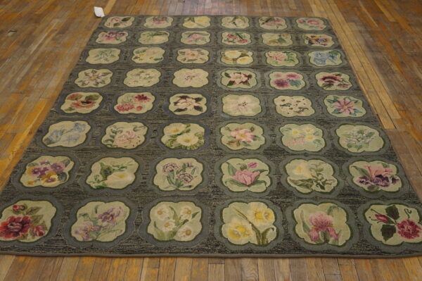 Textured gray rug with a grid of lobed medallions containing multicolored floral designs on wood flooring.