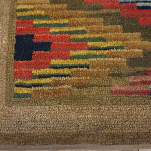 Hooked-style rug featuring a multi-colored geometric pattern against a textured solid brown border on wood floor.