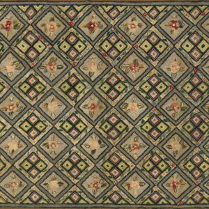 Rustic, textured rug in muted gray and earth tones, featuring alternating diamond floral and geometric designs.