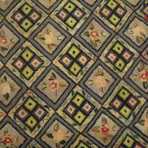 Textured hooked rug featuring a gray and green diamond lattice pattern with alternating floral and geometric motifs.