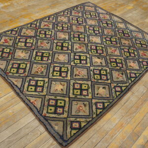 Textured gray and multicolored rug with alternating floral and windowpane squares laid diagonally on distressed wood floor.