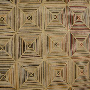 Geometric hooked rug featuring nested squares filled with varied vertical and horizontal stripes in many earthy colors.