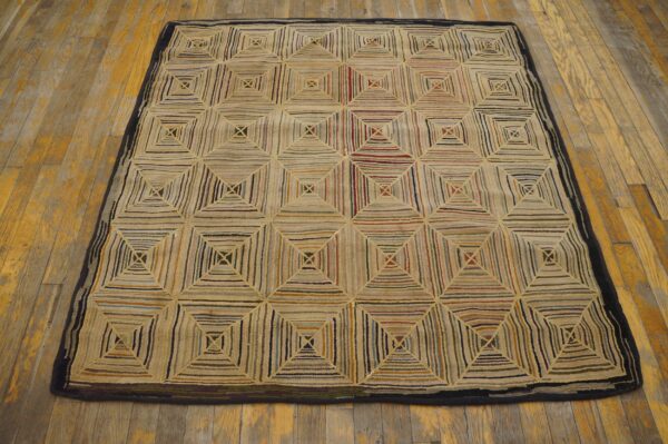 Textured multicolored rug featuring a pattern of concentric squares on worn yellow-gold wooden flooring.