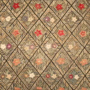 Hooked rug featuring a dark trellis holding diamonds filled with multicolored floral motifs.