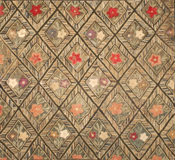 Hooked rug featuring a dark trellis holding diamonds filled with multicolored floral motifs.