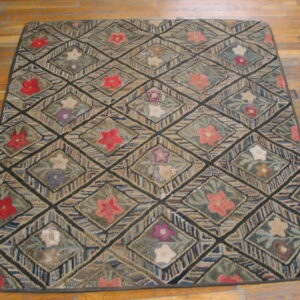 Hooked texture rug with diagonal lattice of multicolored stripes and central floral designs on wood planks.