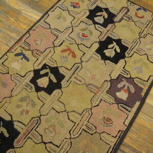 A textured runner rug with chartreuse lattice and multicolored floral blocks rests on wood planks.