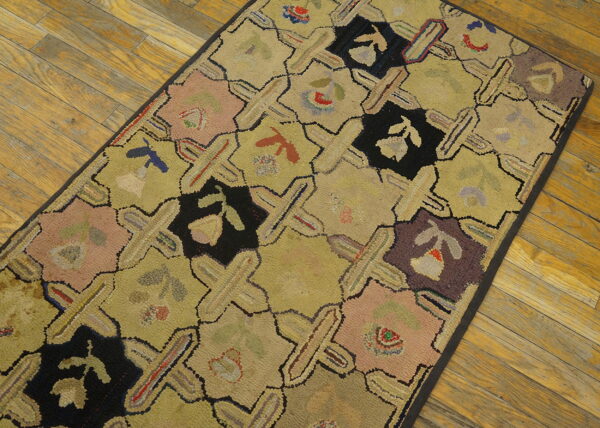 A textured runner rug with chartreuse lattice and multicolored floral blocks rests on wood planks.