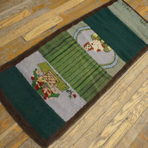 A small green and gray pictorial rug featuring flowers and a dog rests on light-colored wood planks.