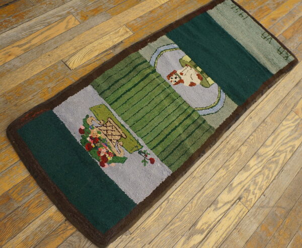 A small green and gray pictorial rug featuring flowers and a dog rests on light-colored wood planks.
