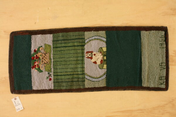 A hooked rug runner on wood flooring features green, gray, and brown panels with dog and floral motifs.