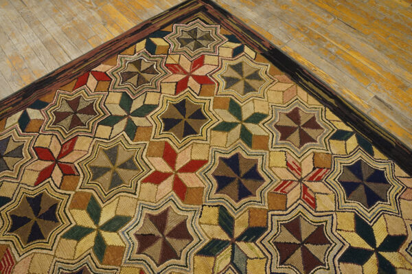 A highly textured rug featuring repeating red, green, and brown star patterns on distressed wood flooring.