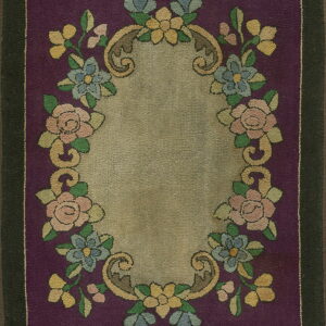 Plum rug featuring a low-pile floral medallion design in tan, pastel pink, blue, and yellow with a dark border.
