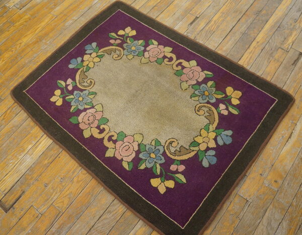 Purple and beige low-pile rug featuring a colorful floral garland border on rustic wood floors.