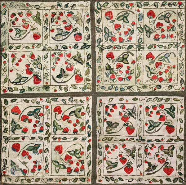 Textured cream rug featuring red strawberry and green leaf motifs arranged in four dark-bordered panels.