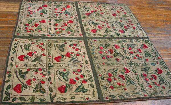 Low-pile rug with red strawberry and green leaf motifs in framed panels lies on wood flooring.