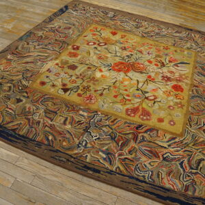 Textured rug with a yellow floral medallion and a wide, swirling multi-color border on distressed wood floors.
