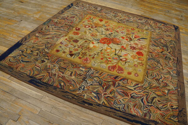 Textured rug with a yellow floral medallion and a wide, swirling multi-color border on distressed wood floors.