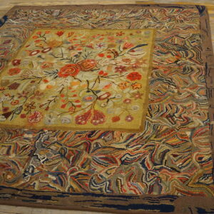 Multicolored hooked rug displaying a floral medallion and abstract swirling patterns on wood floors.