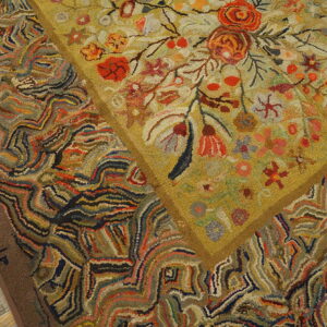 Multicolored high-pile rug detail showing a floral center framed by abstract, striped patterns on wood.