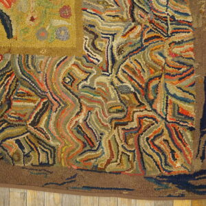 High-pile, multicolored hooked rug displaying abstract swirling patterns and a yellow corner on light wood planks.