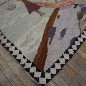 Textured light gray and brown abstract rug corner with a dark checkered border sits on distressed wood flooring.